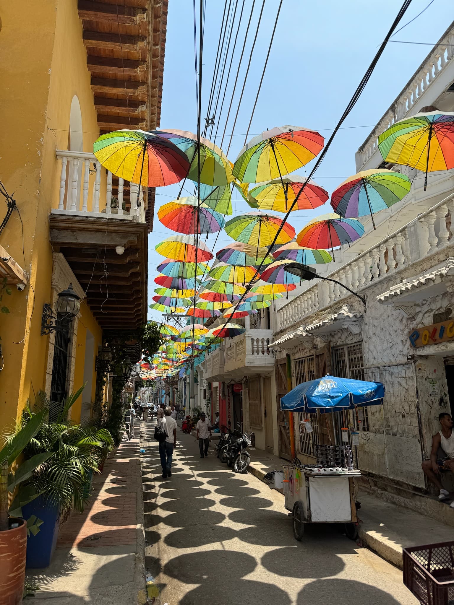 Rainbow umbrellas over a narrow street in Cartagena